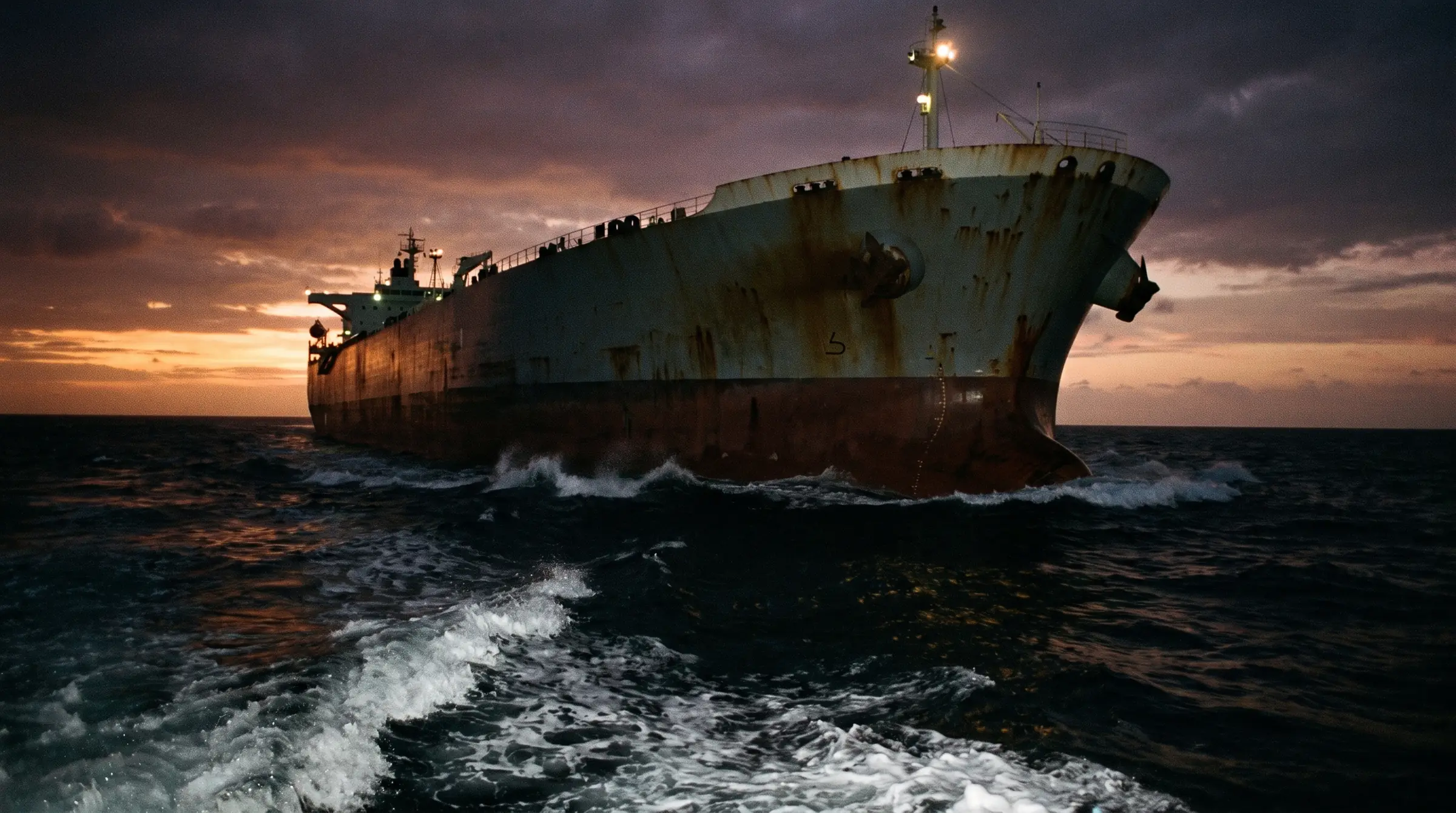 Нос гружёного нефтяного танкера в море в сумерках